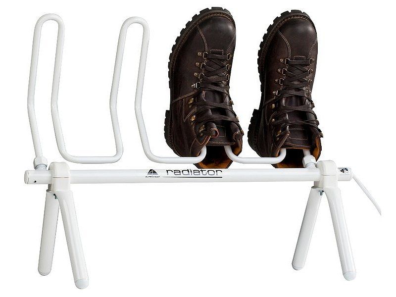 A white radiator-style shoe dryer with brown shoes placed on it, designed by Alpenheat to dry footwear.